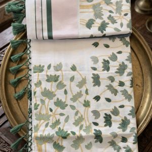 padma kerala saree features allover floral prints, a zari border, and green tassel.